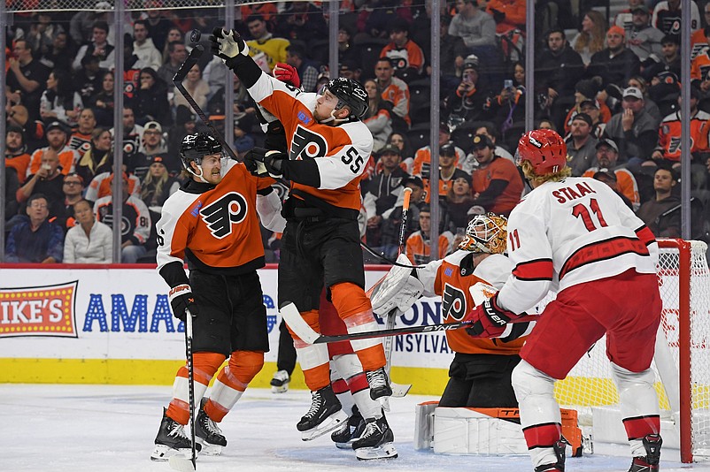 Nov 20, 2024; Philadelphia, Pennsylvania, USA; Philadelphia Flyers defenseman Rasmus Ristolainen (55) jumps for the puck with defenseman Travis Sanheim (6) against the Carolina Hurricanes during the third period at Wells Fargo Center. Mandatory Credit: Eric Hartline-Imagn Images