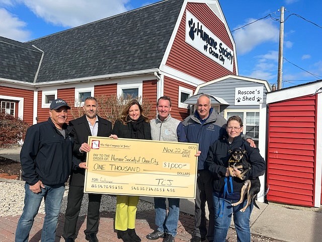 The check presentation ceremony includes, from left, Phil Bellucci, executive director of HSOC, Bryan Durnan and Audrey Hand, both of The Title Company of Jersey, Mayor Jay Gillian, HSOC CEO Bill Hollingsworth and HSOC Director of Operations Courtney Venzie along with Charlie, a 2-year-old Chihuahua-mix available for adoption. (Photo provided)