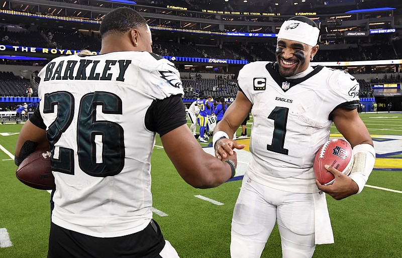 Nov 24, 2024; Inglewood, California, USA;  Philadelphia Eagles quarterback Jalen Hurts (1) celebrates with running back Saquon Barkley (26) after the Eagles defeat the Los Angeles Rams during the first half at SoFi Stadium. Mandatory Credit: Alex Gallardo-Imagn Images