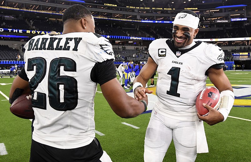 Nov 24, 2024; Inglewood, California, USA;  Philadelphia Eagles quarterback Jalen Hurts (1) celebrates with running back Saquon Barkley (26) after the Eagles defeat the Los Angeles Rams during the first half at SoFi Stadium. Mandatory Credit: Alex Gallardo-Imagn Images