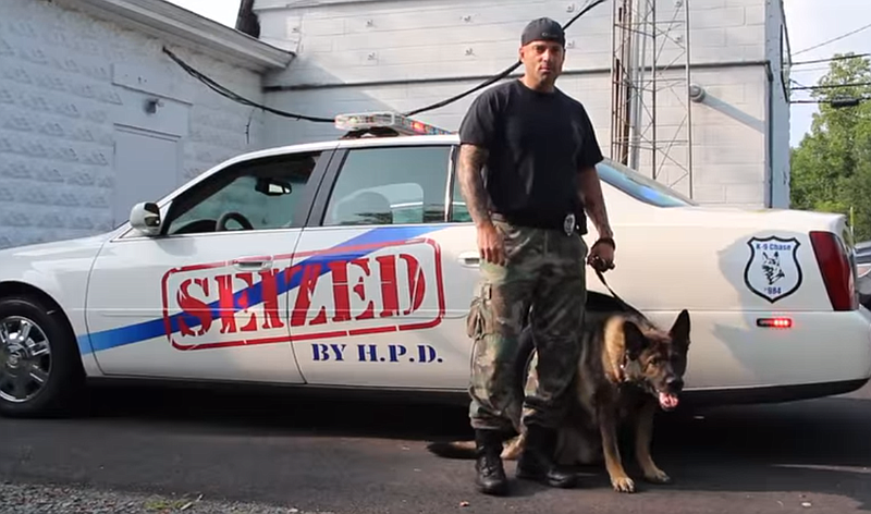 K-9 Officer Robert Zbikowski and his partner, Chase, with the vehicle bearing the dog's name.