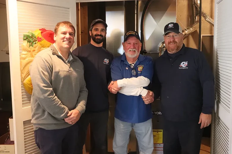 John Nicholas, a Vietnam veteran of Telford (center), poses for a picture with C&C Heating and Air Conditioning Managing Director Josh Hill and technicians Charles Eckert and Mike McConnell in front of his new HVAC system.