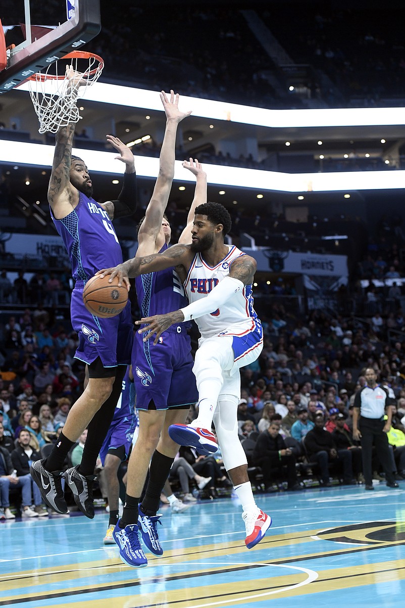 Dec 3, 2024; Charlotte, North Carolina, USA; Philadelphia 76ers forward Paul George (8) passes through the defense of Charlotte Hornets center Nick Richards and forward Tidjane Salaun (31) during the first half at the Spectrum Center. Mandatory Credit: Sam Sharpe-Imagn Images