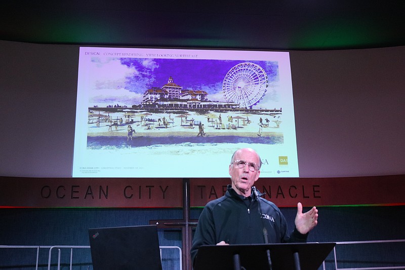 Eustace Mita makes a presentation on his hotel project while standing in front of a rendering.