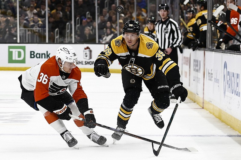 Dec 7, 2024; Boston, Massachusetts, USA; Boston Bruins center Morgan Geekie (39) and Philadelphia Flyers defenseman Emil Andrae (36) look for a loose puck during the first period at TD Garden. Mandatory Credit: Winslow Townson-Imagn Images