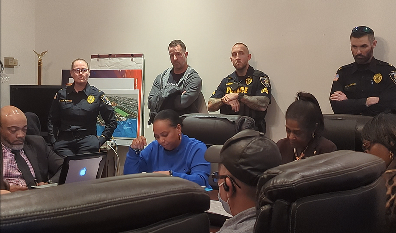 City Council President Carla Thomas, in blue, leads the vote as acting Police Chief Stacey Schlachter and other officers look on.