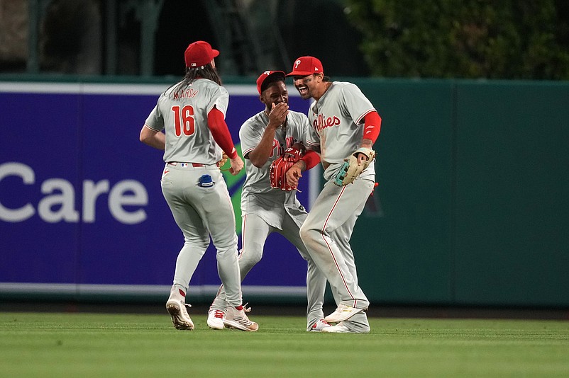 Apr 30, 2024; Anaheim, California, USA; Philadelphia Phillies outfielder Brandon Marsh (16), center fielder Johan Rojas (18) and right fielder Nick Castellanos (8) celebrate after the game against the Los Angeles Angels at Angel Stadium. Mandatory Credit: Kirby Lee-USA TODAY Sports