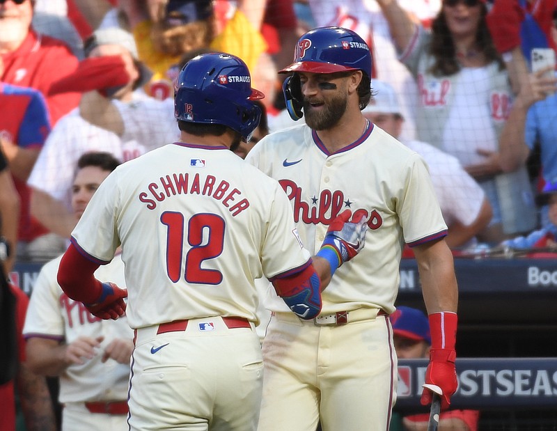 Oct 5, 2024; Philadelphia, PA, USA;  Philadelphia Phillies designated hitter Kyle Schwarber (12) celebrates with Philadelphia Phillies first baseman Bryce Harper (3) after a solo home run against the New York Mets in the first inning in game one of the NLDS for the 2024 MLB Playoffs at Citizens Bank Park. Mandatory Credit: Eric Hartline-Imagn Images