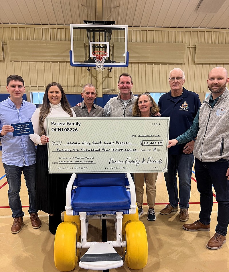 The check presentation ceremony included, from left to right, Joe Kuerzi, fiancé of Nicole Pacera (Terry’s daughter), Joseph Pacera (Terry’s husband), Mayor Jay Gillian, Surf Chair Program Coordinator Kristie Fenton, City Councilman Dave Winslow and Community Services Director Dan Kelchner. (Courtesy of Ocean City)