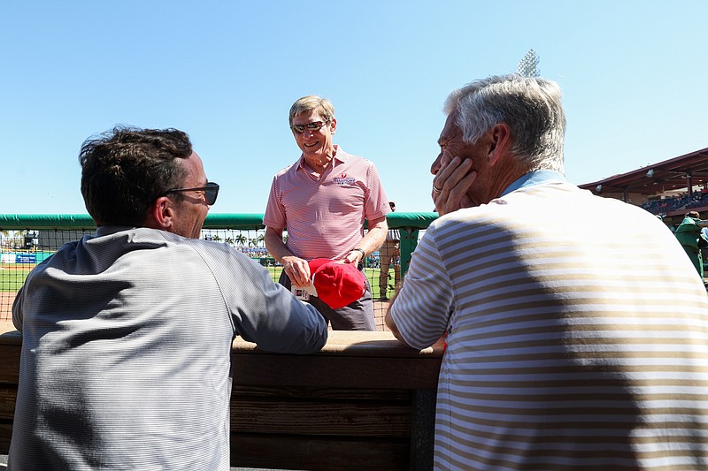 Feb 25, 2024; Clearwater, Florida, USA;  Philadelphia Phillies managing partner and principal owner John Middleton (center), president of baseball operations Dave Dombrowski and general manager Sam Fuld talk in the dugout before a game against the New York Yankees at BayCare Ballpark. Mandatory Credit: Nathan Ray Seebeck-USA TODAY Sports