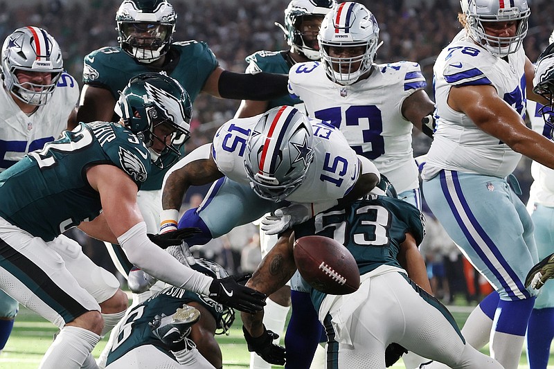 Nov 10, 2024; Arlington, Texas, USA; Dallas Cowboys running back Ezekiel Elliott (15) fumbles the ball after bring hit by Philadelphia Eagles cornerback Cooper DeJean (33) in the second quarter at AT&T Stadium. Mandatory Credit: Tim Heitman-Imagn Images