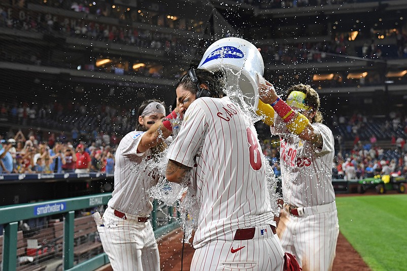 Sep 1, 2024; Philadelphia, Pennsylvania, USA;  Philadelphia Phillies outfielder Nick Castellanos (8) has water dumped on him by outfielder Brandon Marsh (16) and second base Bryson Stott (5) after his walk-off single during the eleventh inning against the Atlanta Braves at Citizens Bank Park. Mandatory Credit: Eric Hartline-USA TODAY Sports