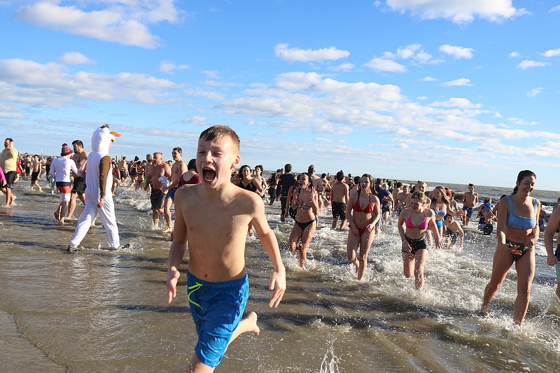 Plungers emerge from the ocean after charging into the frosty surf.