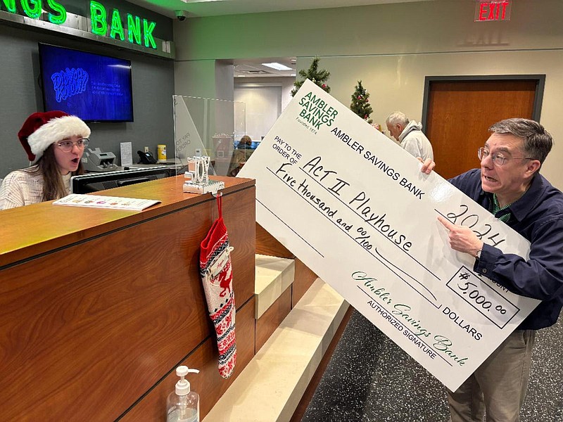 Act II Playhouse's Artistic Director Tony Braithwaite attempts to deposit an oversized check. (Image courtesy of Act II Playhouse)