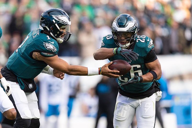 Dec 8, 2024; Philadelphia, Pennsylvania, USA; Philadelphia Eagles quarterback Jalen Hurts (1) hands off to running back Saquon Barkley (26) during the third quarter against the Carolina Panthers at Lincoln Financial Field. Mandatory Credit: Bill Streicher-Imagn Images