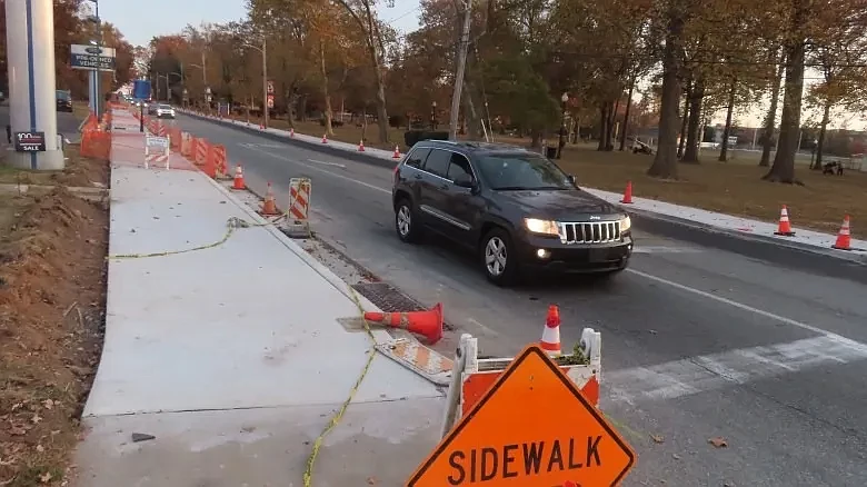 Cars pass a “Sidewalk closed” sign and new sidewalks and drainage upgrades on Main Street east of Line Street in Lansdale in Oct. 2024.