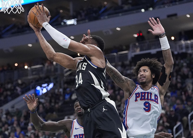 Jan 19, 2025; Milwaukee, Wisconsin, USA; Milwaukee Bucks forward Giannis Antetokounmpo (34) drives tot he basket against Philadelphia 76ers guard Kelly Oubre Jr. (9) in the firs half at Fiserv Forum. Mandatory Credit: Michael McLoone-Imagn Images