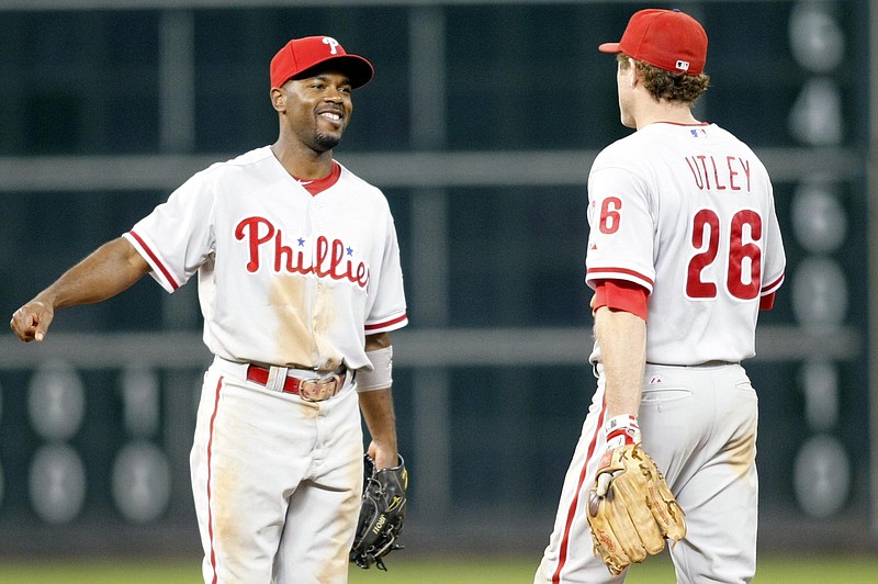 Sep 14, 2012; Houston, TX, USA; Philadelphia Phillies shortstop Jimmy Rollins (11) and second baseman Chase Utley (26) celebrate a victory against the Houston Astros in the ninth inning at Minute Maid Park. The Phillies defeated the Astros 12-6. Mandatory Credit: Brett Davis-USA TODAY Sports.