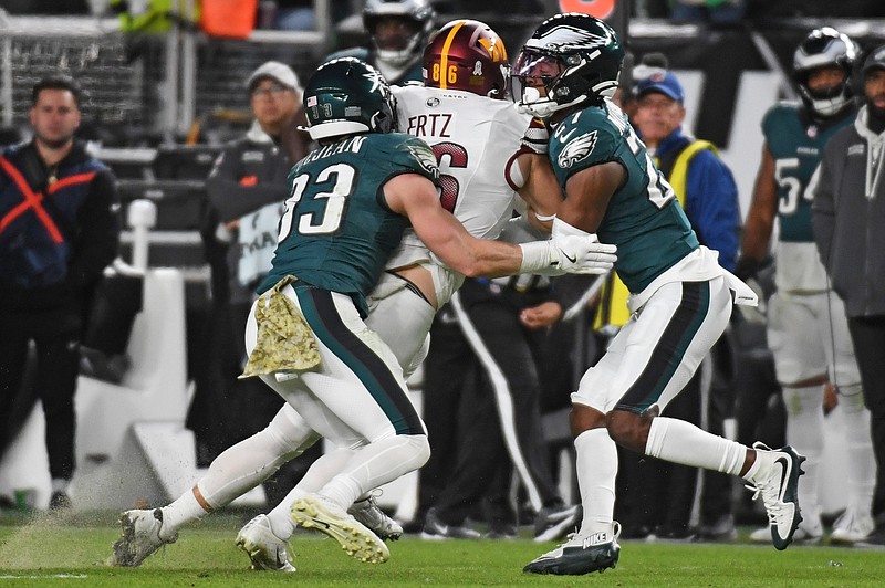 Nov 14, 2024; Philadelphia, Pennsylvania, USA; Philadelphia Eagles cornerback Cooper DeJean (33) and cornerback Quinyon Mitchell (27) tackle Washington Commanders offensive tackle Brandon Coleman (74) at Lincoln Financial Field. Mandatory Credit: Eric Hartline-Imagn Images