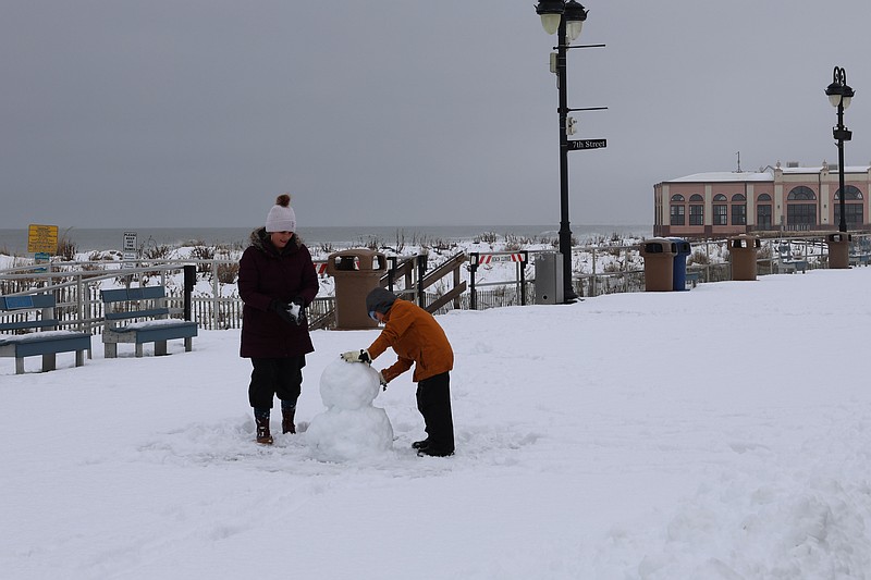 Jill Chin and her son, Sebastian, have fun building a snowman on the Ocean City Boardwalk. (Photos by Max Kelly)