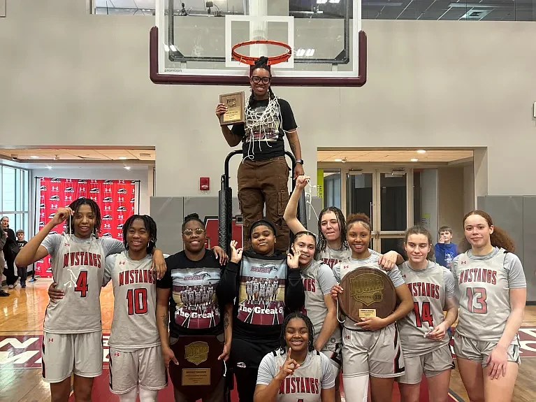 The Montgomery County Community College Mustangs women’s basketball team celebrates their historic victory after defeating Rowan College of South Jersey, Gloucester, 48-42 to win the North Atlantic District Championship — securing their first-ever Region Championship and a spot in the NJCAA Division III National Championship tournament. (Credit: Kelly Dunbar)