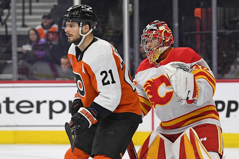 Mar 4, 2025; Philadelphia, Pennsylvania, USA; Philadelphia Flyers center Scott Laughton (21) screens Calgary Flames goaltender Dustin Wolf (32) during the first period at Wells Fargo Center. Mandatory Credit: Eric Hartline-Imagn Images