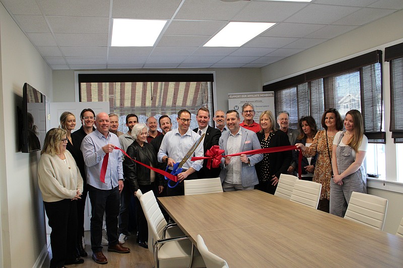 Ocean City Board of Realtors President Pete Madden cuts the ribbon during the ceremony to celebrate the upgraded office. (Photo courtesy of Ocean City Regional Chamber of Commerce.