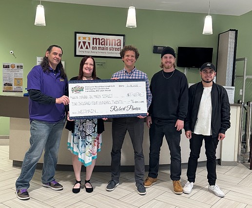 Panico's owner Rob Panico, left, and Westmain frontman Billy Andrey, second from right, present a check to Manna on Main Street earlier this year. (Credit: Dave Heck)