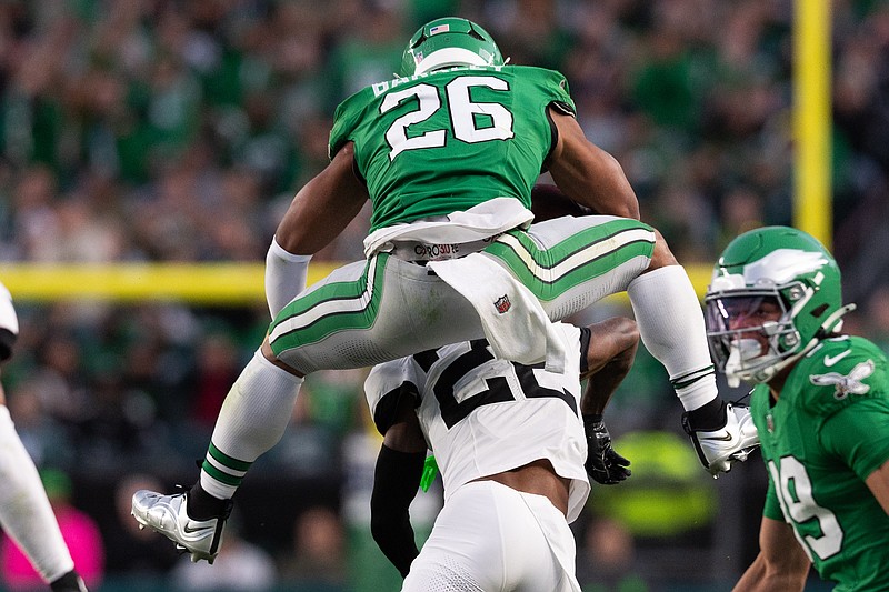 Nov 3, 2024; Philadelphia, Pennsylvania, USA; Philadelphia Eagles running back Saquon Barkley (26) leaps with the ball over Jacksonville Jaguars cornerback Jarrian Jones (22) during the second quarter at Lincoln Financial Field. Mandatory Credit: Bill Streicher-Imagn Images