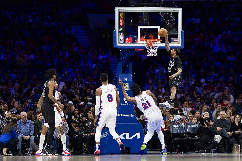 Feb 22, 2025; Philadelphia, Pennsylvania, USA; Brooklyn Nets guard Keon Johnson (45) drives for a dunk in front of Philadelphia 76ers center Joel Embiid (21) during the third quarter at Wells Fargo Center. Mandatory Credit: Bill Streicher-Imagn Images