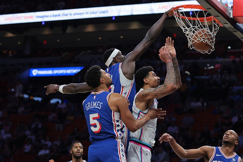 Apr 7, 2025; Miami, Florida, USA; Miami Heat center Kel'el Ware (7) dunks past Philadelphia 76ers center Adem Bona (30) and guard Quentin Grimes (5) during the first quarter at Kaseya Center. Mandatory Credit: Sam Navarro-Imagn Images