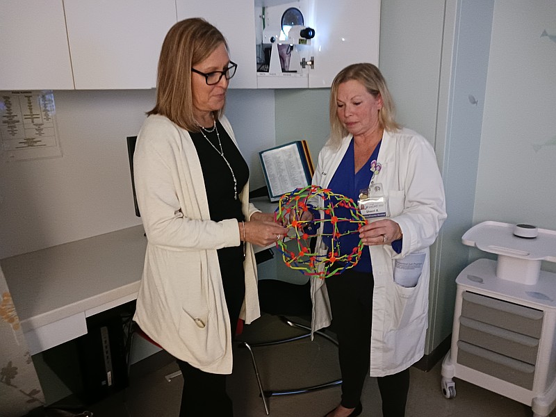 Jen Cruickshank, left, supervisor of the child study team at the Atlantic County Special Services School District, and Sherri Richmond, Shore Medical Center's director of emergency services, look at one of the sensory toys in a children's exam room.