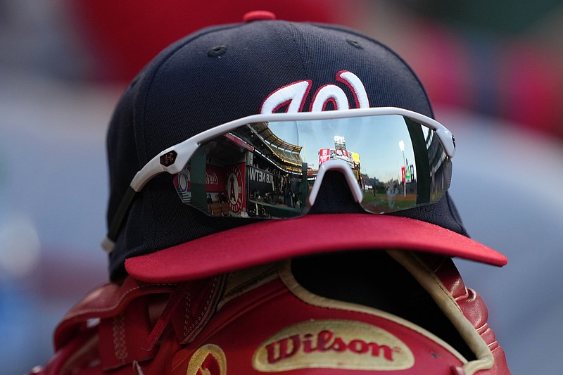 May 7, 2022; Anaheim, California, USA; A detailed view of a Washington Nationals cap and glove with sunglasses in the dugout before a game against the Los Angeles Angels at Angel Stadium. Mandatory Credit: Kirby Lee-USA TODAY Sports