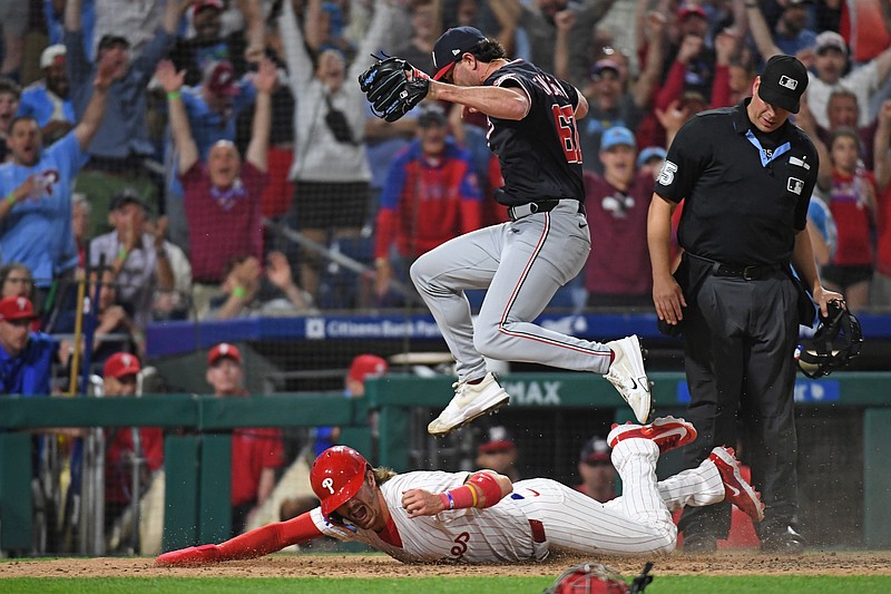 Apr 29, 2025; Philadelphia, Pennsylvania, USA; Washington Nationals pitcher Kyle Finnegan (67) jumps over Philadelphia Phillies second base Bryson Stott (5) after he scored the winning run on a wild pitch during the ninth inning at Citizens Bank Park. Mandatory Credit: Eric Hartline-Imagn Images