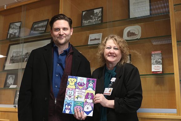Bucks County’s Anthony Pacifico and Lower Bucks Hospital’s LeeAnn Morsa holding one of the coloring books.
