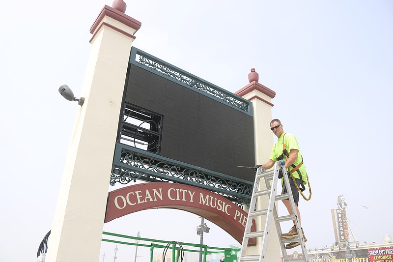 KC Sign supervisor Craig Spangler installs the new digital marquee in front of the Ocean City Music Pier.