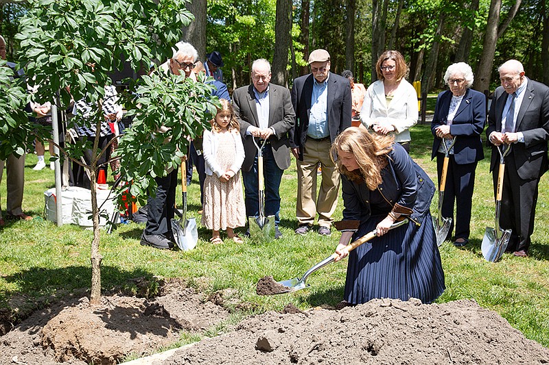 Toby Rosenthal shovels dirt onto the sapling planted in honor of her mother, Gail Hirsch Rosenthal. (Photo by Bernard DeLury III/Stockton University)