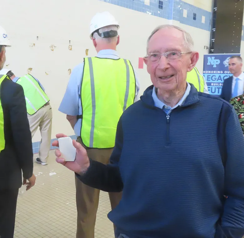 Longtime North Penn swim coach Rick Carroll holds a shard of tile from a wall at the soon-to-be-renovated North Penn High School’s Rick Carroll Natatorium on Monday, May 19, 2025.
