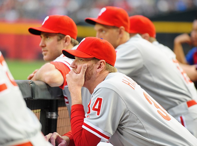 Apr. 23, 2012; Phoenix, AZ, USA; Philadelphia Phillies pitcher Roy Halladay (center) watches from the bench alongside Chase Utley in the first inning against the Arizona Diamondbacks at Chase Field. Mandatory Credit: Mark J. Rebilas-USA TODAY Sports