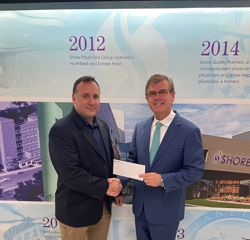 Somers Point School Superintendent Ted Pugliese, left, accepts the donation from Shore Medical Center President and CEO David Hughes. (Photo courtesy of Shore Medical Center)