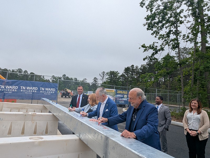 The final beam was signed by those gathered before being placed on the 40,000-square-foot structure.
