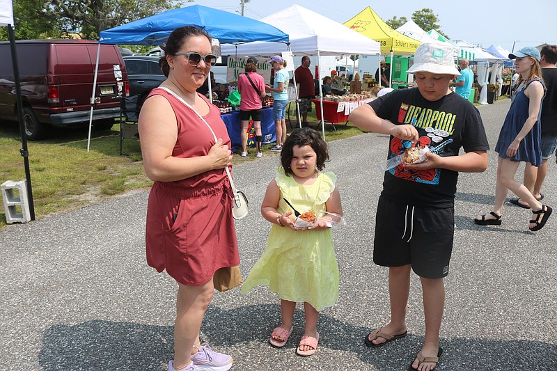 Katie Weisenbarger watches while her daughter, Audrey, and son, Leo, enjoy some monkey bread at Ocean City's Farmers & Crafters Market.