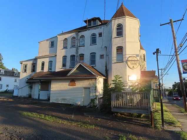 A setting sun reflects off of a window near the entrance to the former McKeever’s building on Walnut Street in North Wales, as seen in June 2022.
