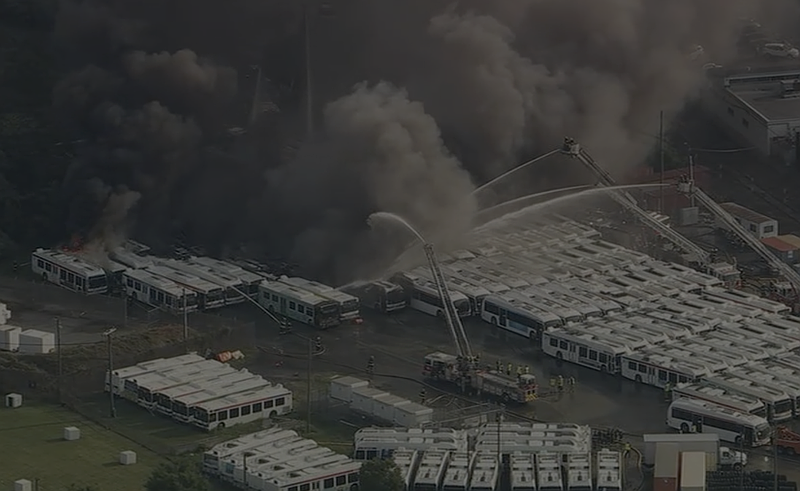 A plume of thick black smoke is visible as firefighters contain a fire in a SEPTA bus yard in the Nicetown–Tioga section of Philadelphia. (Credit: 6abc Action News)