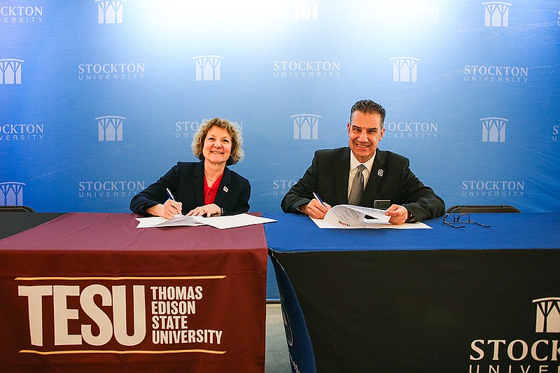 Cynthia Baum, provost of Thomas Edison State University, and Michael Palladino, provost and vice president for Academic Affairs at Stockton University, sign an agreement as Stockton joins the New Jersey Prior Learning Assessment Network. (Stockton University/Edward Lea)