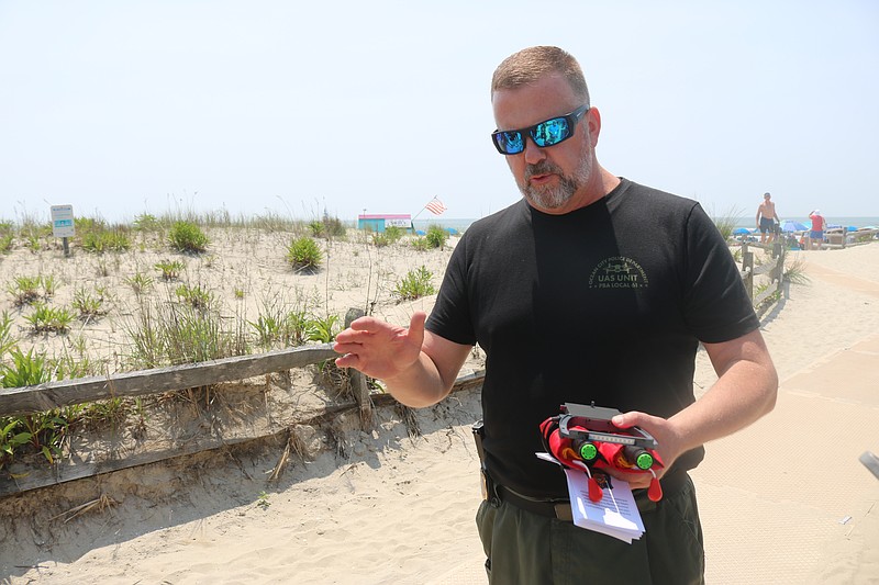 Lt. Mark Pancoast, head of the police department's drone unit, explains how the inflatable tubes save lives while showing them to the media.