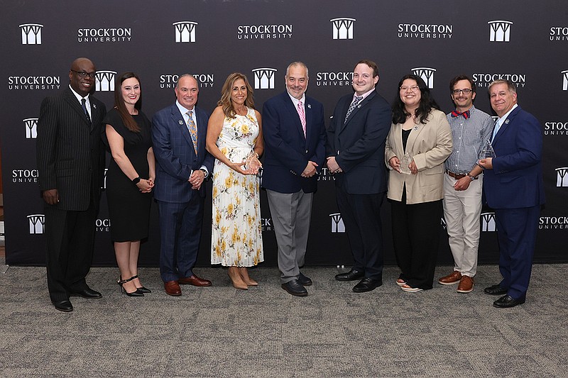 The recipients of the 2025 Stockton University Alumni Achievement Awards are, from left, Kennard Weever '95, Siera Smith Vargas '14, Mark Giannantonio '87, Susan Adelizzi-Schmidt MBA '05, President Joe Bertolino, Matthew Greer '15, Andrea Sandoval '25, Eddie Horan '14, and Henry Glickel '85. (Stockton University)