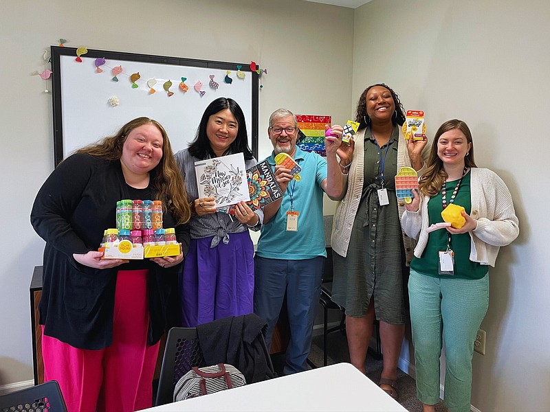 (Left to right): NOVA Counselors Sydney Finsel, Jee Soo Lee, Kevin Keller, Ray'ven Hudley, and Beth Haff pose with some of the comfort items that were donated by the Danaher Lynch Family Foundation Scholars Program and students at Our Lady of Grace Elementary School, in Penndel. The items help reduce anxiety, promote relaxation, and support self-regulation, making it easier for NOVA’s clients to engage in the therapeutic process. (Credit: Debbie Goetz)