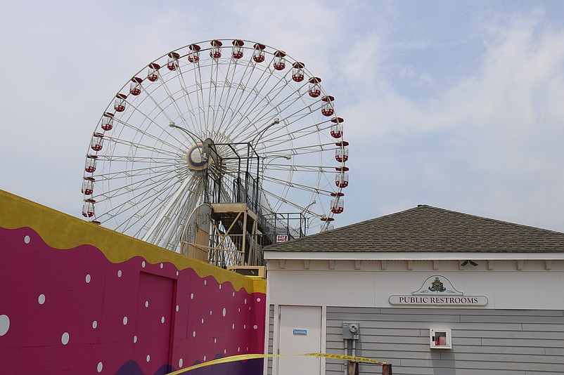 Wonderland Pier's landmark Ferris wheel remains idle now while tucked behind a closed gate.