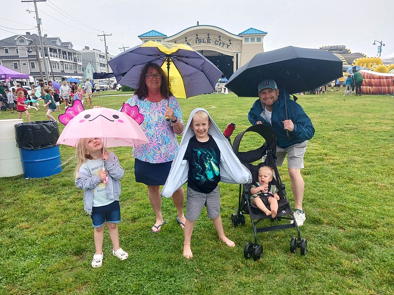 The Sabin family ducks under their umbrellas for cover from the light rain.